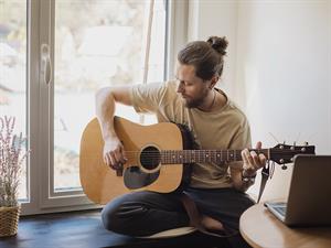 shutterstock_1700608642_playing guitar_spēlē uz ģitāras.jpg