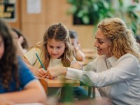 shutterstock_2641535877_teacher helping girl_skolotāja palīdz meitenei.jpg