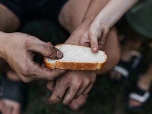 shutterstock_2539252931_Child gives homeless man piece of bread_bērns dod maizi bezpajumtniekam.jpg