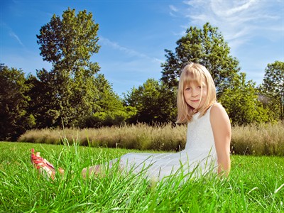 shutterstock_291376181_little girl sitting on green grass_meitene sēž zālienā.jpg