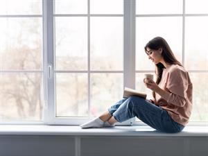 Shutterstock_1959786922_girl reading on window_meitene lasa uz loga.jpg