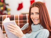 shutterstock_228745723_redhead woman reading book at Christmas_ruda sieviete lasa grāmatu Ziemassvētkos.jpg