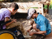 shutterstock_1595355292_father helping his disabled son_tēvs palīdz savam bērnam ar invaliditāti.jpg