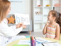 shutterstock_2413875521_little girl with speech therapist_meitene pie logopēda.jpg