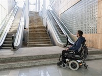 shutterstock_2200996515_man in wheelchair in front of staircase_vīrietis ratiņkrēslā pie trepēm.jpg