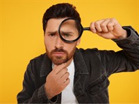 Shutterstock_2379365781_Man looking through magnifier glass_Vīrietis skatās caur palielināmo stiklu.jpg