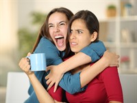 shutterstock_2399040079_Excited woman hugging to an upset friend_Sajūsmināta sieviete apskauj apjukušu draudzeni.jpg