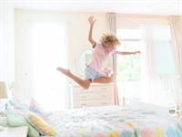 Shutterstock_2271071045_kid jumping on bed_bērns lēkā uz gultas.jpg