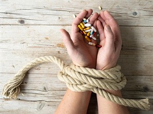 shutterstock_1951133980_tied hands with pills_sasietas rokas ar tabletēm.jpg