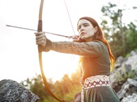 shutterstock_2021315288_red haired girl archer_ruda meitene šauj ar loku.jpg