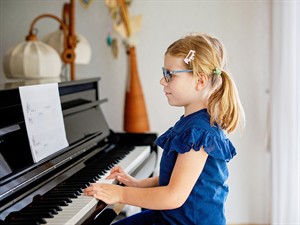 shutterstock_2340020675_girl playing piano_meitene spēlē klavieres.jpg