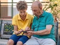 shutterstock_2507145263_grandson teaches granddad using phone_mazdēls māca vectēvu izmantot telefonu.jpg