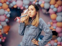 shutterstock_2210921209_Woman Blowing a Party Whistle_sieviete pūš papīra svilpē.jpg