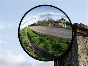 shutterstock_2288366927_round road mirror_izliekts spogulis uz ceļa.jpg