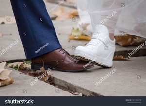 stock-photo-bride-s-foot-in-white-sneakers-steps-on-the-groom-s-foot-on-brown-shoes-in-autumn-among-the-leaves-1871954770.jpg
