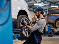 shutterstock_2725106585_mechanic changing car tire_mehāniķis maina riepu mašīnai.jpg