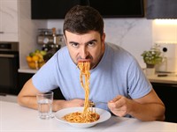 shutterstock_2237967983_man eating pasta with bad maners_vīrietis ēd makaronus bez manierēm.jpg