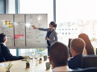 Shutterstock_2460912847_whiteboard and woman speaker_tāfele un sieviete, runātāja.jpg