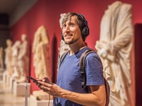 shutterstock_2306258537_man listening excursion in museum_vīrietis klausās ekskursiju muzejā.jpg