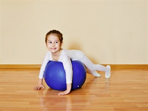 shutterstock_426469564_kid girl doing gymnastic exercises_Maza meitene nodarbojas ar vingrošanu.jpg