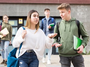 shutterstock_2524216051_teenagers walking out of school_pusaudži dodas prom no skolas.jpg