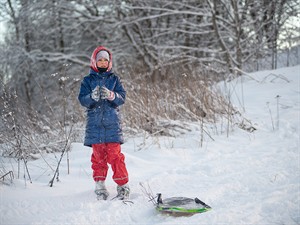 shutterstock_2710316631_girl with a sled on a snowy winter slope_meitene ar ragavām uz sniegota kalna.jpg