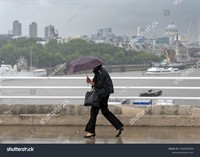 stock-photo-london-united-kingdom-july-th-people-cross-the-river-thames-in-wind-and-rain-2432823009.jpg