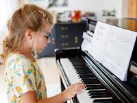 Shutterstock_2519723609_girl playing piano_meitene spēlē klavieres.jpg