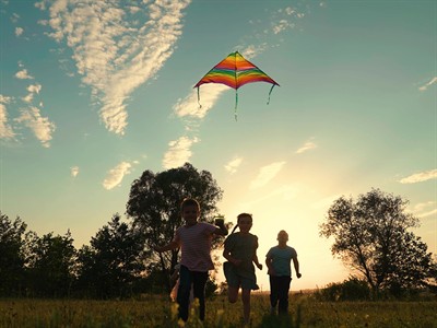 shutterstock_2353381931_Children play in park with kite_Bērni parkā spēlējas ar gaisa pūķi.jpg