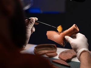 shutterstock_2411397223_archeologist cleaning antique vessel_arheologs tīra antīku trauku.jpg