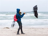 shutterstock_744428686_woman tries to hold an umbrella in a storm_sieviete cenšās noturēt lietussargu vētras laikā.jpg