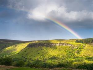 shutterstock_2052220268_rainbow on hill_varavīksne uz paugura.jpg